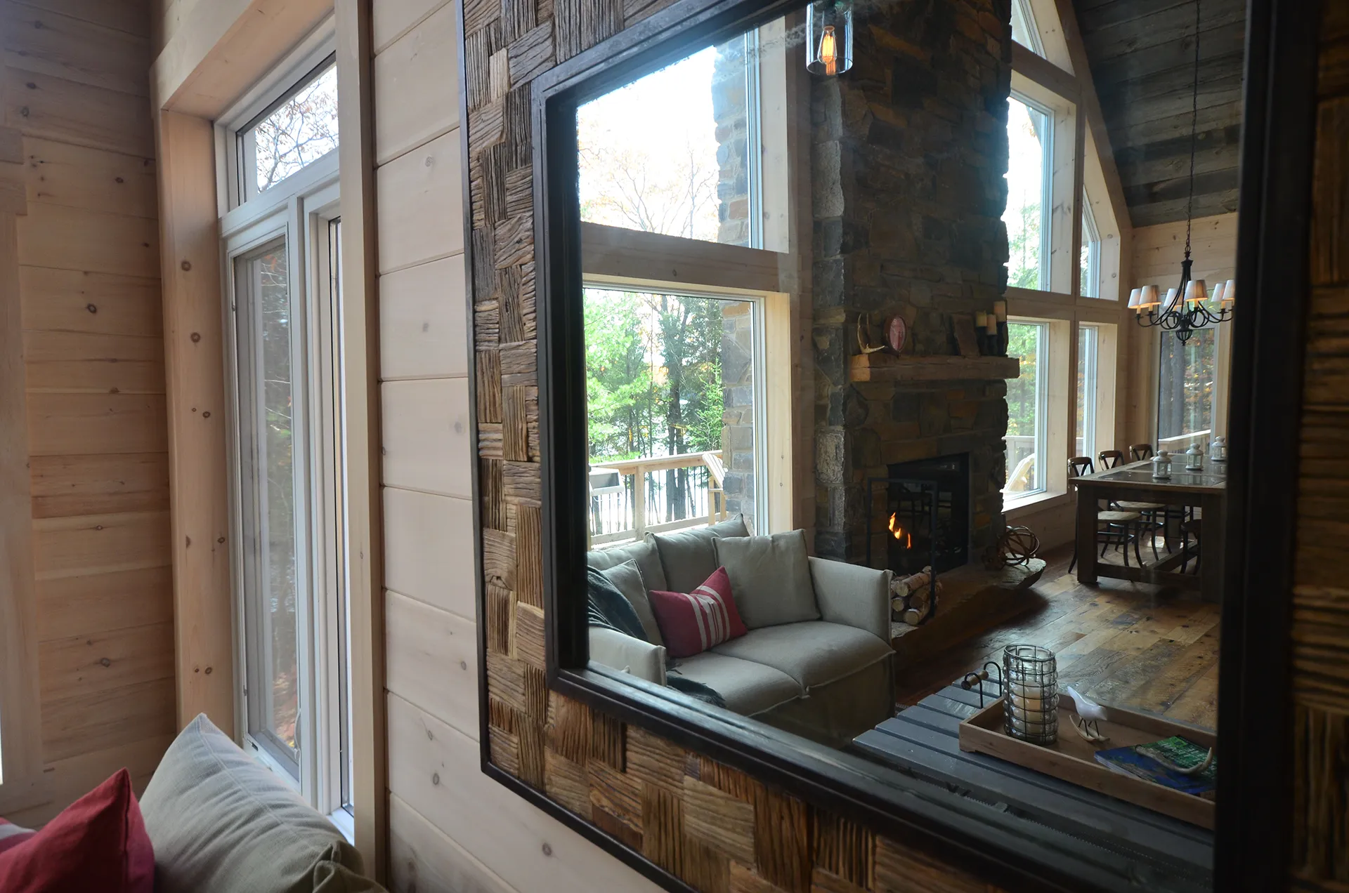Muskoka room with reclaimed barn wood and a stone fireplace overlooking the lake